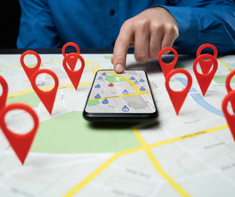 Person using smartphone with map and multiple red location pins representing local SEO and map services